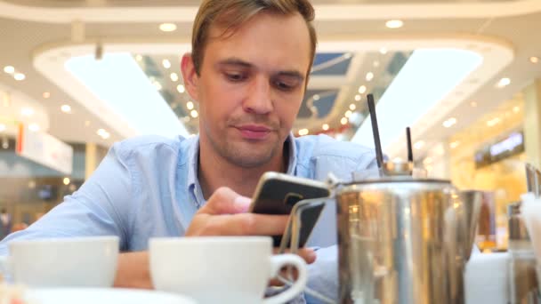 Sad man waiting for someone in cafe and drinking tea. 4k, slow-motion, close-up, copy space. — Stock Video