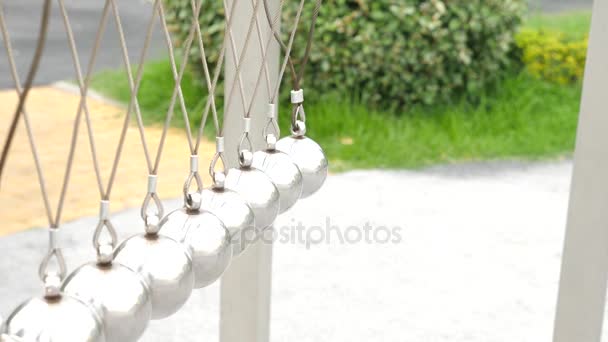 Newtons Wiege: ein Pendel mit schwingenden Metallkugeln. in einem Freizeitpark in der Natur. 4k — Stockvideo