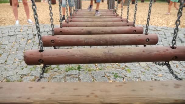 Gros plan des jambes des enfants allant sur un pont suspendu à Ropes Park. Espace de copie 4K. mode de vie, ralenti — Video