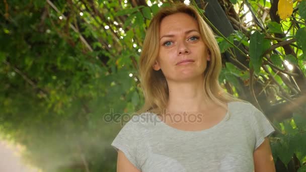 Junge Frau genießt eine erfrischende Dusche durch Bewässerung in einem tropischen Garten. Zeitlupe. 4k, Kopierraum — Stockvideo