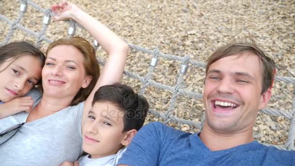 Familia relajándose en una hamaca tropical, en un parque de atracciones de la ciudad. Hágase uno mismo en la cámara. 4k. espacio para copiar, cámara lenta — Vídeos de Stock