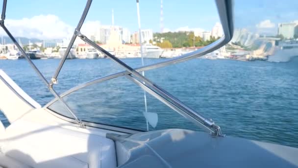 Olas de agua azul del mar, mientras que el barco se mueve rápido. vista de la ciudad desde el mar. 4k, primer plano, espacio para copiar. Movimiento lento — Vídeos de Stock