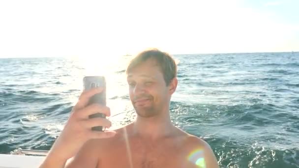 Un bel ragazzo fa selfie a bordo di uno yacht. 4K, primo piano, copiare spazio. Rallentatore — Video Stock