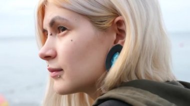 bodimodification, bir kız yüz piercing ve kulakları tünellerde portresi. bir kız bir split dil ile. dili gösterir. 4k, ağır çekim silah, kopyalama alanı
