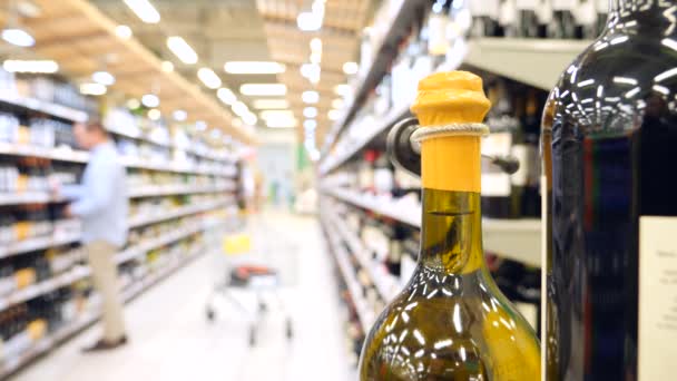 Un joven romántico elige vino para una cena romántica. comprando alcohol. 4k, cámara lenta, desenfoque — Vídeos de Stock