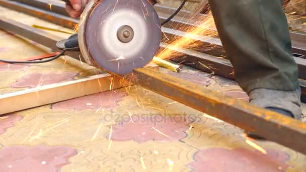 Arbeiter schneidet mit einem Winkelschleifer ein Metallrohr in zwei Stücke. 4k, Zeitlupe — Stockvideo