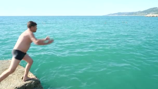 Człowiek nurkowania off molo w morzu. 4k, zwolnionym tempie — Wideo stockowe