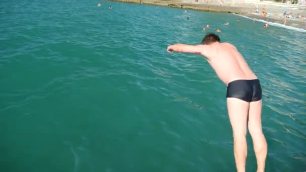 Taucht der Mann von der Seebrücke ins Meer. 4k, Zeitlupe — Stockvideo