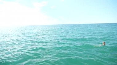 Sarışın güzel kadının açık deniz, suda yüzen. Yukarıdan görüntüleyin. Ağır çekim.