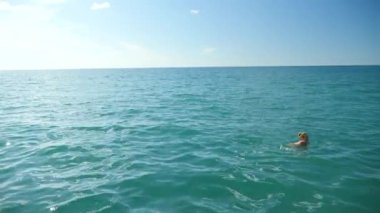 Sarışın güzel kadının açık deniz, suda yüzen. Yukarıdan görüntüleyin. Ağır çekim.