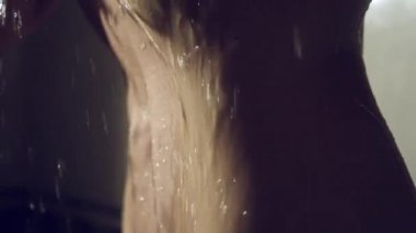 kadın süper ağır çekim bir duş alıyor. genç kız altında duş oynayan ve suyun keyfini çıkarın .