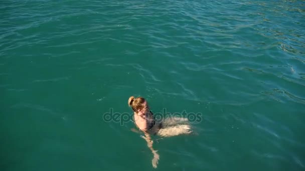 Mujer guapa rubia disfrutando del agua en el mar abierto, flotando. Vista desde arriba. Movimiento lento . — Vídeos de Stock