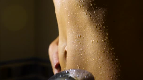 Женщина принимает душ в замедленной съемке. молодая девушка под душем играет и наслаждается водой  . — стоковое видео