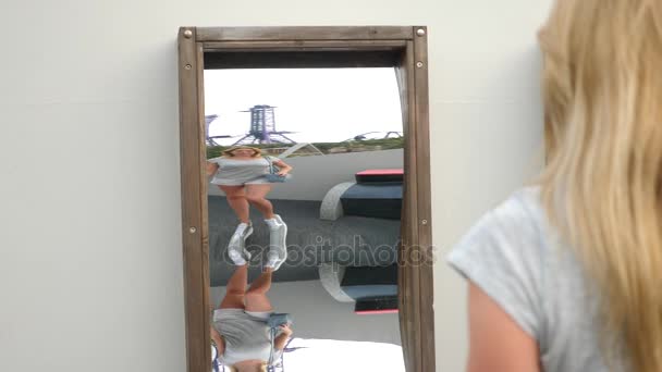 Une femme prend son reflet dans un faux miroir sur la caméra. voyage mode de vie. Elle rit et elle est idiote. 4k. Mouvement lent — Video