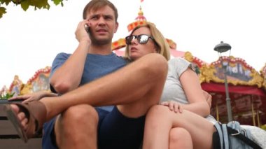 Mutlu aile Lunaparktaki bir bankta oturup ve eğlenin. 4 k yavaş hareket. kopya alanı. yaşam tarzı