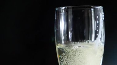 yakın çekim, siyah bir zemin üzerine bir bardak şampanya köpük. ağır çekim