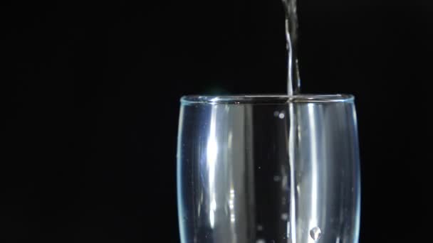 gros plan, champagne moussant dans un verre sur fond noir. 4k, au ralenti 
