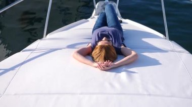 Çekici kadın bir yatta. açık denizde bir teknenin güvertesinde uzun saçlı ince busty sarışın. 4 k. ağır çekim