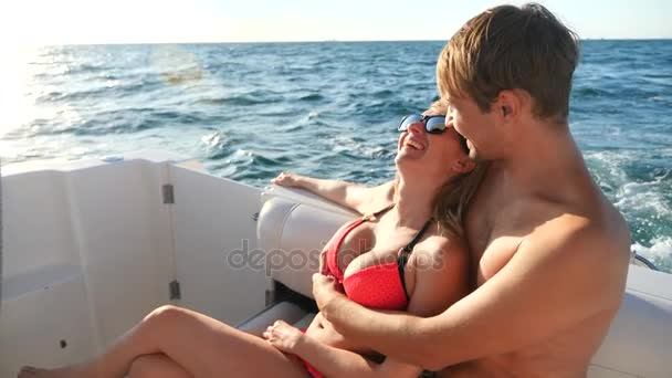 Щаслива любляча пара дивиться вбік, сидячи разом на яхті. 4k, повільний рух — стокове відео