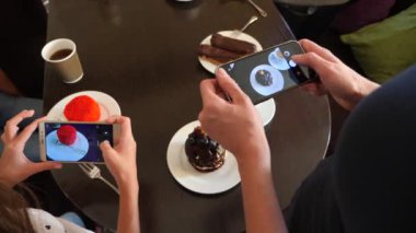 kadın fotoğraf üstünde onların smartphone sosyal ağlarda düzenlemeniz için bir kafede lezzetli güzel tatlılar eller. 4k, yavaş çekim