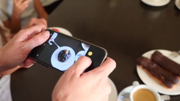 Kadın fotoğraf üstünde onların smartphone sosyal ağlarda düzenlemeniz için bir kafede lezzetli güzel tatlılar eller. 4k, yavaş çekim — Stok video