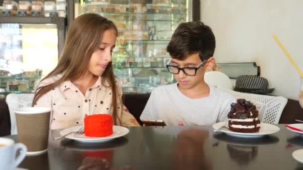 Niños, hermano y hermana, gemelos comen un delicioso postre en un café. 4k cámara lenta — Vídeos de Stock