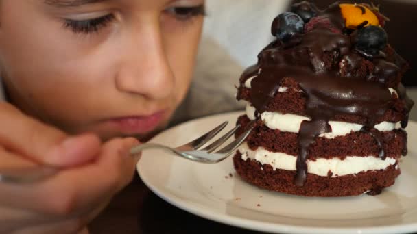 Le garçon à lunettes mange un délicieux dessert dans un café. 4k au ralenti — Video