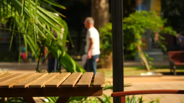 Fundo borrado de café da rua, transeuntes, as pessoas passam por uma mesa de um café de rua. 4k, câmera lenta — Vídeo de Stock