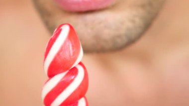 seksi bir adam bir lolipop yemek. oral seks simülasyonu. şeker, 4 k, ağır çekim yalama dil. kopya alanı