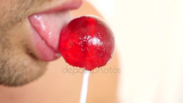 Sexy pareja hombre y mujer comiendo una piruleta. simulación de sexo oral. lengua lamiendo dulces. 4k, espacio de copia en cámara lenta. beso — Vídeos de Stock