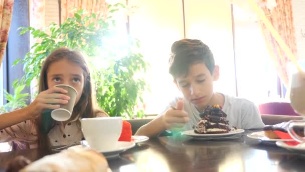 Kinderen, broer en zus, tweeling eet een heerlijk dessert in een café. 4 k slow-motion — Stockvideo