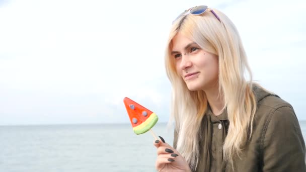 Bodymification. en flicka med en split-tunga slickar lollipop. 4k, Slowmotion-skytte, kopiering utrymme — Stockvideo