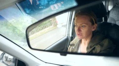 Dikiz aynasından mavi gözler, kadın direksiyonuna bir womans yüzle yansımasıdır. 4k, ağır çekim