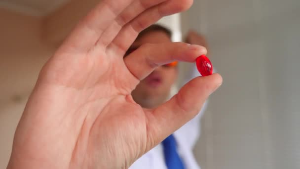 Ein verrückter Professor, ein Arzt mit roter Brille reicht der Zelle eine Pille. 4k, Zeitlupe — Stockvideo