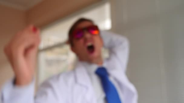 Deli Profesör doktor kırmızı gözlük bir hap hücreye sunmaktadır. 4k, ağır çekim — Stok video