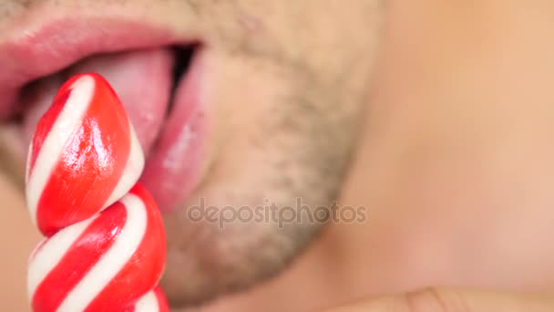 Chico sexy comiendo una piruleta. simulación de sexo oral. lengua lamiendo caramelos, 4k, cámara lenta. espacio de copia — Vídeo de stock