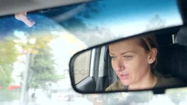 Dikiz aynasından mavi gözler, kadın direksiyonuna bir womans yüzle yansımasıdır. 4k, ağır çekim