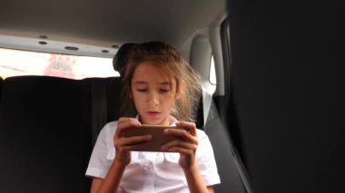 Genç kız bir araba yolculuk sırasında bir akıllı telefon kullandığından konsantre. 4 k yavaş hareket