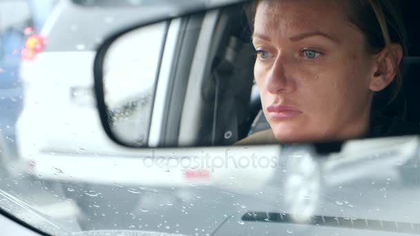 Reflet d'un visage de femme aux yeux bleus dans le rétroviseur, femme au volant. 4k, au ralenti — Video