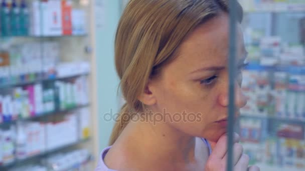 这个女人看起来在药房窗口的药物。4 k 慢动作 — 图库视频影像