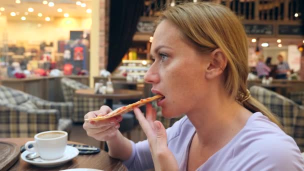 La mujer come pizza en la cafetería. 4k, grabación en cámara lenta, espacio para copiar — Vídeo de stock