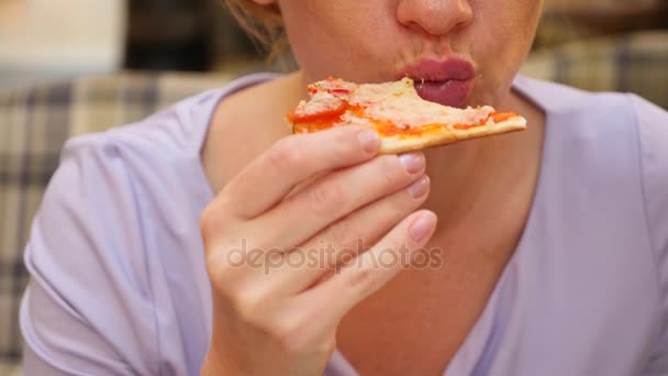 Une femme mange de la pizza au café. 4k, prise de vue au ralenti, espace de copie — Video