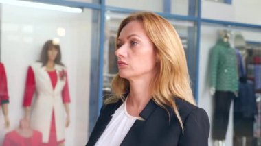 iş takım elbiseli bir kadın vitrinler yürür. 4k, ağır çekim