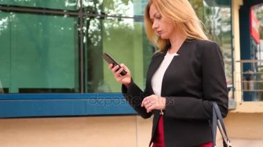 bir iş merkezi city, steadicam atış yürüme yürüyüş iş kadını bir smartphone ile iş takım elbiseli. 4k, ağır çekim, alanı Kopyala