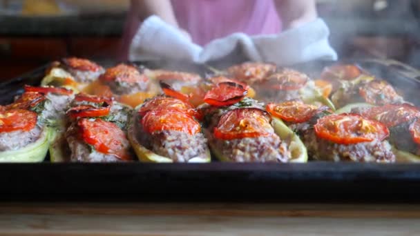 Frauenhände, gefüllte Zucchini. heiße, frisch gebackene, gefüllte Zucchini auf einem Backblech. Nahaufnahme. 4k, Zeitlupe. — Stockvideo