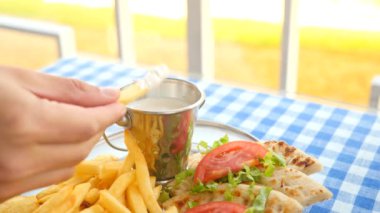 yakın çekim, mens eller Yunan souvlaki ye. Patates kızartması bir parçası haline bir beyaz sos dips. 4k, ağır çekim