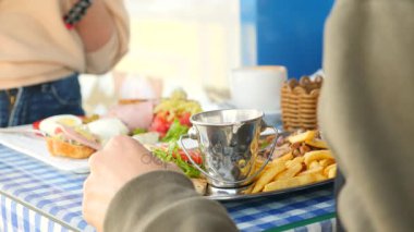 romantik bir çift, bir açık kafe Yunan yemekleri yemek kahvaltı souvlaki ve bir Yunan. 4k, ağır çekim