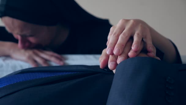 Funeral, sadness and mourning concept - sad woman talking and crying next to the coffin. 4k, — Stock Video