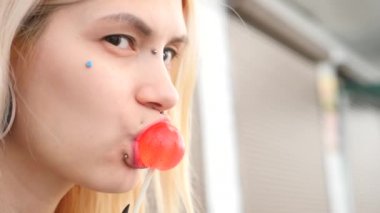 bodymification. bir kız bir split dil ile lolipop yalıyor. 4k, ağır çekim silah, kopyalama alanı