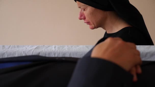 Cenaze, üzüntü ve yas kavramı - söz ve tabutun yanında ağlayan üzgün kadın. 4k, — Stok video
